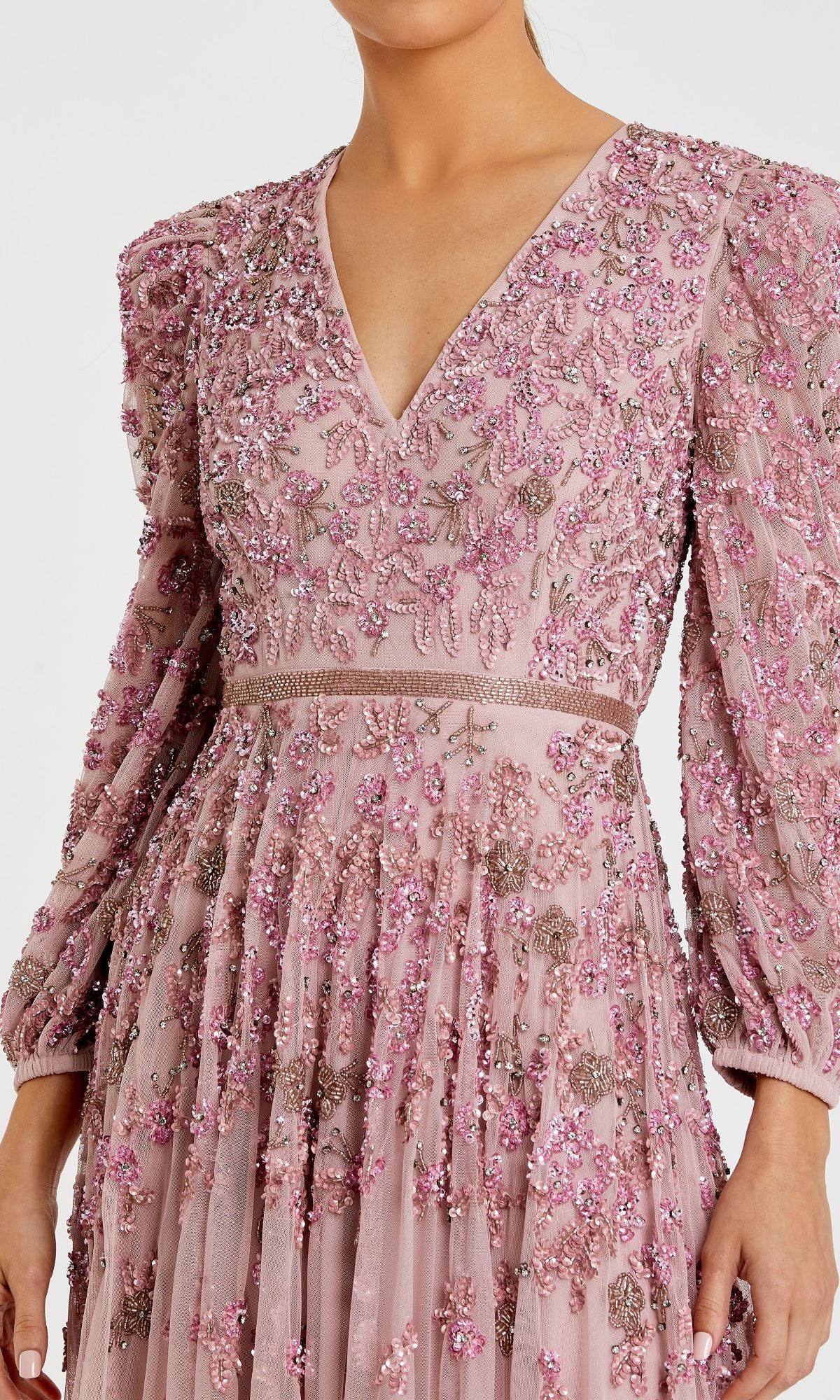 A woman dressed in the Mac Duggal 5497 Long Sleeve Beaded Formal Dress, a modest light pink gown featuring long sleeves and intricate floral beadwork and embroidery.